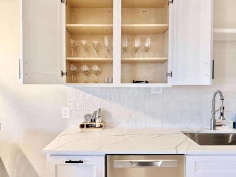 Bright kitchen with sleek countertops and glassware display