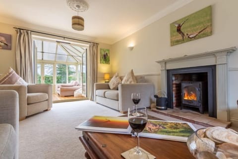 Saltmarshes, Holme: Spacious sitting room with wood burning stove, leading to conservatory