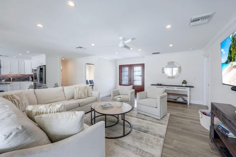 Spacious open-concept living room with soft coastal tones and plenty of seating for the whole group to gather