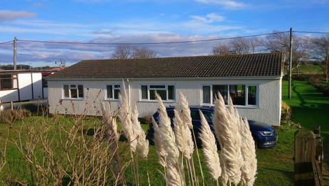 Front of property from the road showing  parking at the front and large garden.