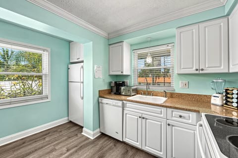 A full kitchen with coastal colors and white appliances—fully stocked and ready for group cooking.