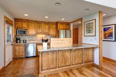 Fully Equipped Kitchen with Stainless Steel Appliances, Granite Countertops, and Side Patio Access.