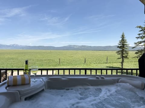 Hot tub with panoramic meadow views.