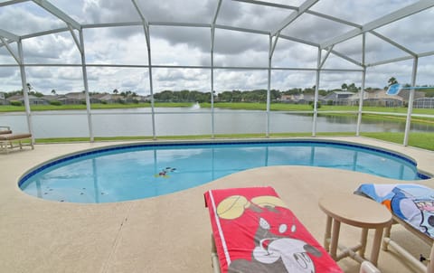 Screened in private pool with lake view and safety fence in a vacation rental near Disney.