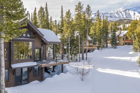 Mountain retreat nestled among snow-covered pines with stunning alpine views and nearby ski access.