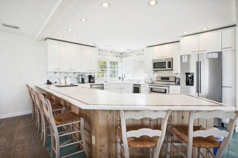 Your dream vacation kitchen awaits—spacious white counters, modern appliances, and a charming farmhouse island where you can gather for meals and memories.