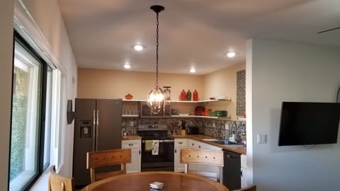 Dining table is near front window which overlooks the pool.