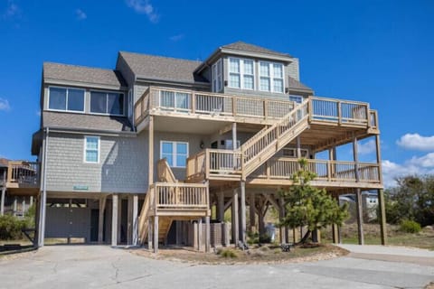 The multi-level coastal home stands elevated on sturdy pilings, offering spacious outdoor decks where guests can soak in the oceanfront surroundings.