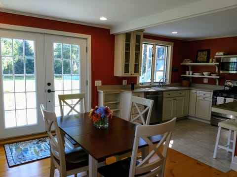 Open kitchen/dining with French doors out to the deck.