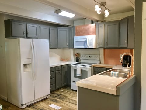 Kitchen with full sized fridge, stove, microwave and dishwasher