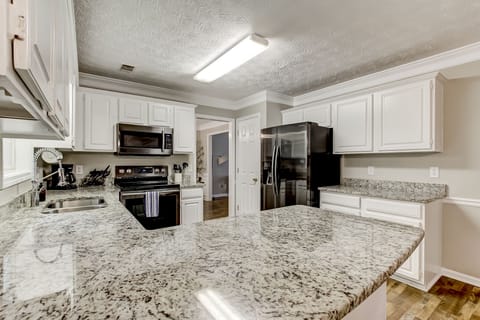 Kitchen with granite countertops open to living room
