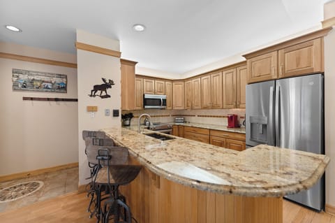 Full kitchen featuring stainless steel appliances, including a wine fridge.