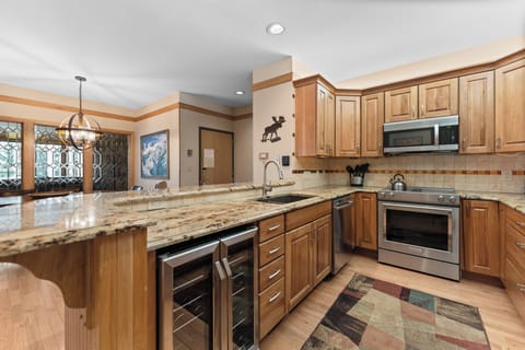 Full kitchen featuring stainless steel appliances, including a wine fridge.