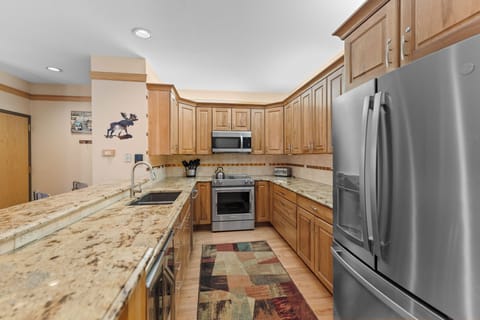 Full kitchen featuring stainless steel appliances, including a wine fridge.