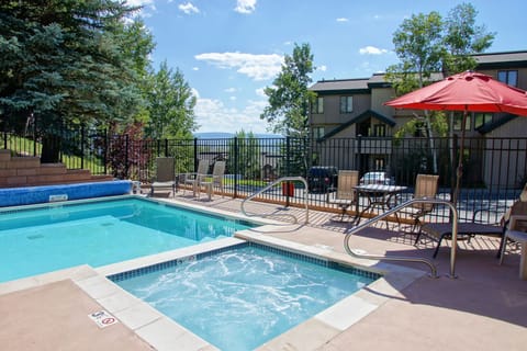 View of the pool and hot tub area with the condo in the background