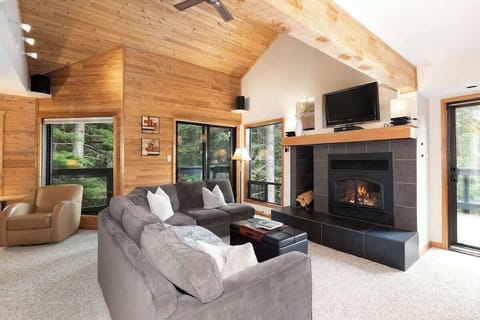 - Inviting living space with large sectional seating  
- Modern fireplace warms up your mountain evenings  
- Rustic wood walls create the perfect cabin feel  

