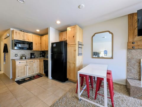 Cook your favorite meals in this fully equipped kitchen with natural wood cabinets, modern appliances, and cozy dining bar seating.