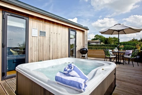 Hot tub on decking with outdoor furniture, BBQ - Perry Lodge, Strawberryfield Park