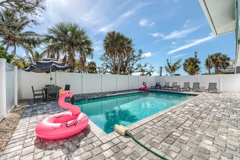 Inviting pool area with loungers & umbrella table