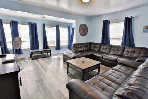 Spacious living room featuring cozy seating, modern accents, and ample natural light, ideal for relaxing or hosting guests.