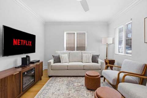 Cozy seating with Smart TV, ceiling fan, and warm natural light.