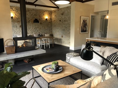 Open plan living, double sided fireplace opens out onto deck with paddock views