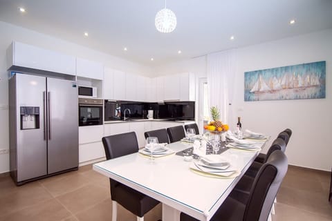 Living and dining area with a table for 12 persons, fully equipped kitchen