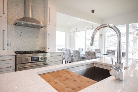 Stainless range & hood, microwave-in-a-drawer, disposal, high-end finishes.