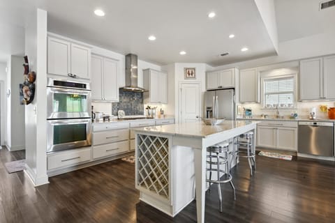Fully stocked kitchen with gas stovetop and two ovens.