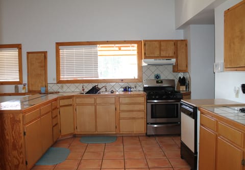 A roomy kitchen with gas stove, dishwasher, fridge and more. 