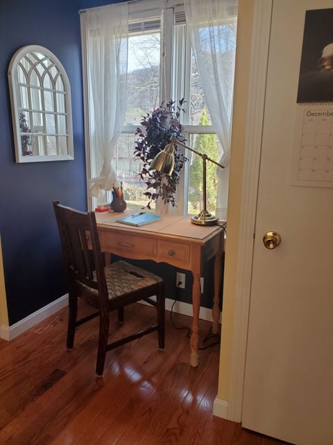 Small desk with wooded views of the pond across the street