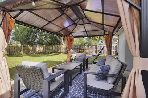 Comfortable conversation set under covered pergola with sunshade and bug screen