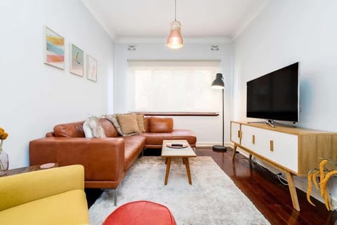 Gather with loved ones in this welcoming living area, complete with a plush leather sectional, stylish accents, and a large TV for shared moments.