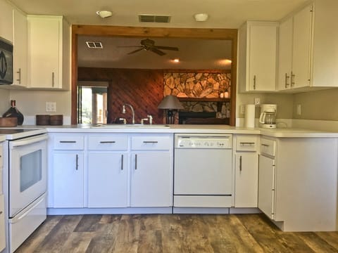 The kitchen, looking through to the living room and fireplace.