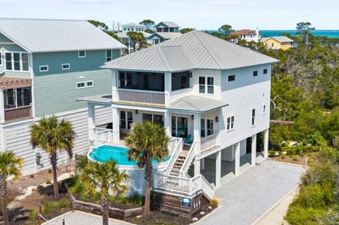 Stunning coastal home with private pool nestled among palm trees in peaceful beachside neighborhood.