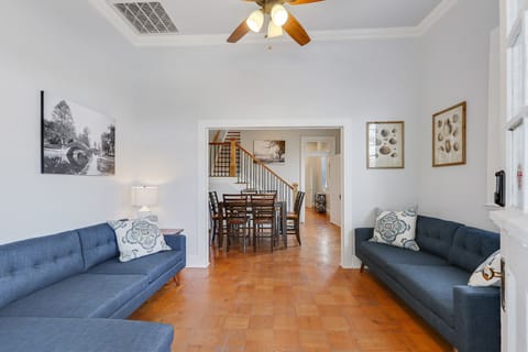 The living room has a large sectional sofa and 60” flat-screen TV