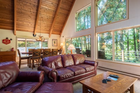 Living Room - Living room with large windows and views of the wooded area and golf course located behind the home. There is a pellet stove and TV in this room as well.
