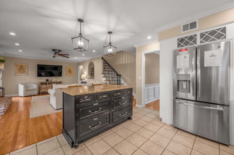 Neat and functional cooking area with bright cabinetry, tile floors, and everything you need for everyday convenience.