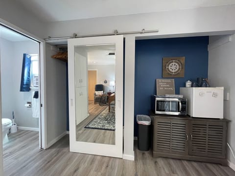 Closet next to the microwave, and small refrigerator. Dishes are in the cabinet.