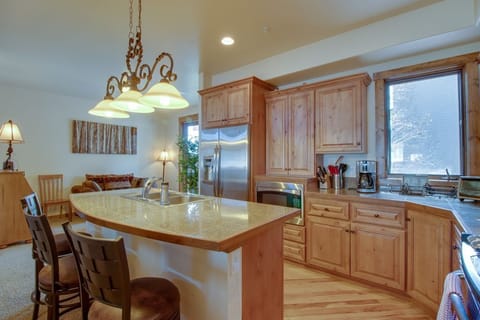 Your fully equipped kitchen features granite countertops, stainless steel appliances, and a breakfast bar where you can enjoy morning coffee while taking in the serene views.