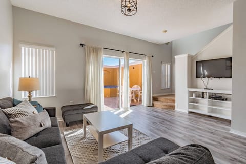 Welcome to a bright living area filled with natural light and soft gray tones. With contemporary furnishings like a plush sectional and stylish coffee table, this space is perfect for relaxing or socializing with friends.