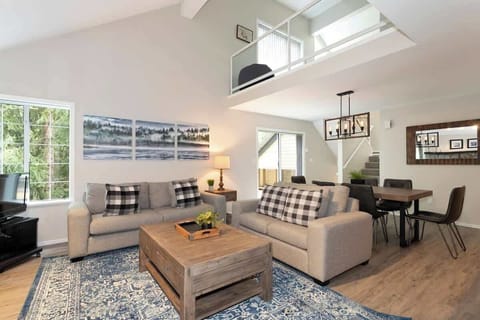 - Spacious living room with cozy cabin decor and natural light  
- Relax with plush sofas and forest views through large windows  
- Perfect family stay with open-concept comfort and charm  