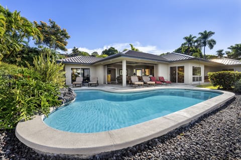 Relax in the solar-heated pool, surrounded by lush tropical landscaping and ocean views.