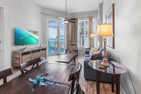 Relax in your bright living space with stunning ocean views through floor-to-ceiling windows and coastal decor throughout.