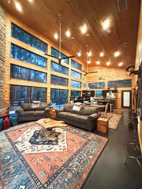 Open living space with fireplace and large windows overlooking nature