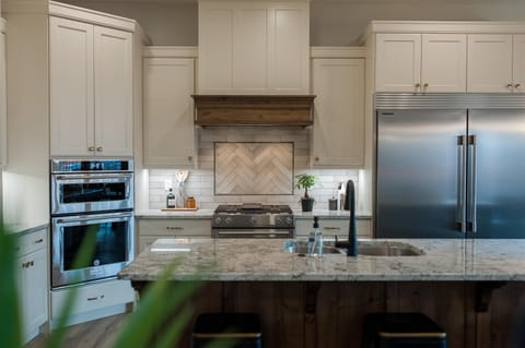 Grand kitchen features a sub-zero style refrigerator, gas range, oven, icemaker