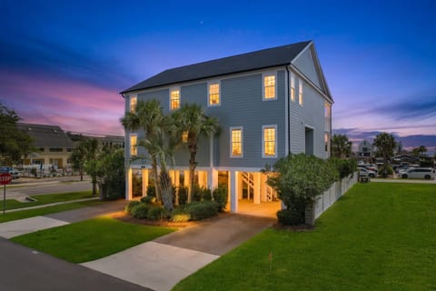 This coastal property is framed by palm trees and bathed in the soft glow of twilight, creating a welcoming retreat after a day of exploring nearby beaches and attractions.