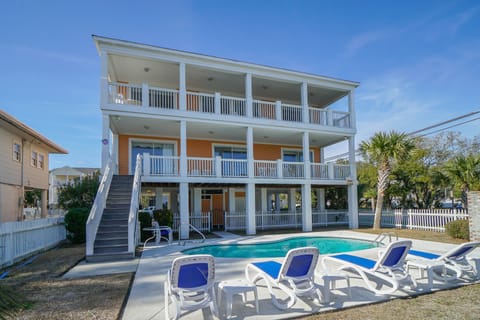 Spacious beach house with multiple balconies, private pool, and palm-lined surroundings perfect for a coastal getaway.