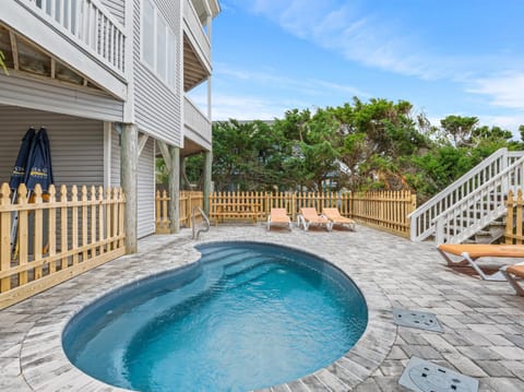 Dive into your own private oasis with this sparkling pool surrounded by comfortable lounge chairs and tropical greenery.