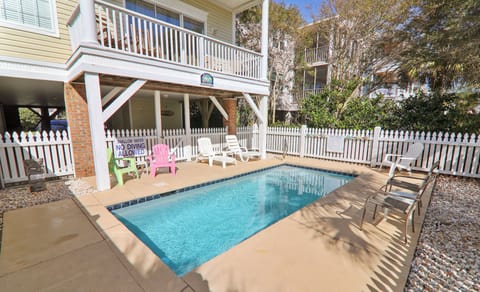 Dive into your private pool oasis, where colorful chairs and shaded lounging await your perfect beach day.